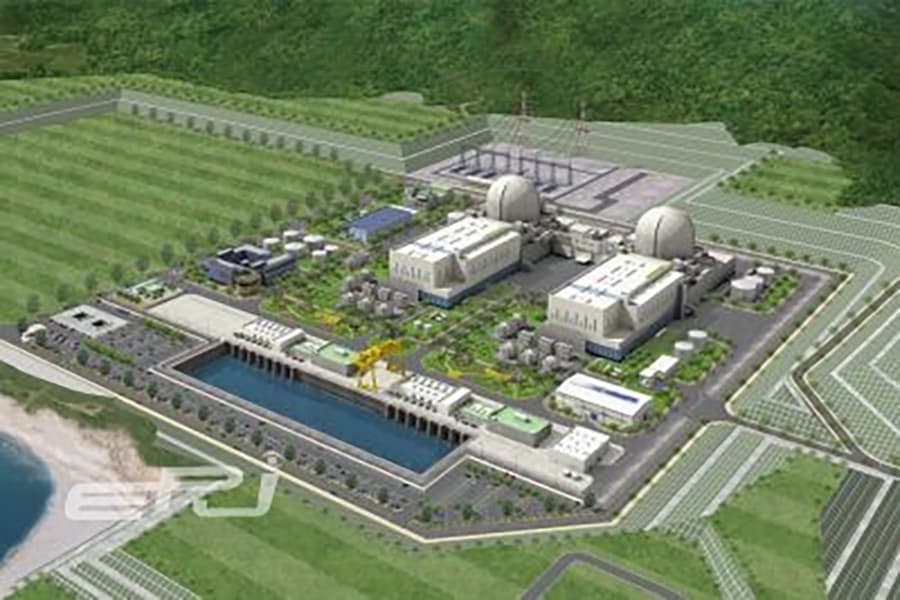 Aerial 3D rendering of a coastal nuclear power plant with two reactor domes and buildings.